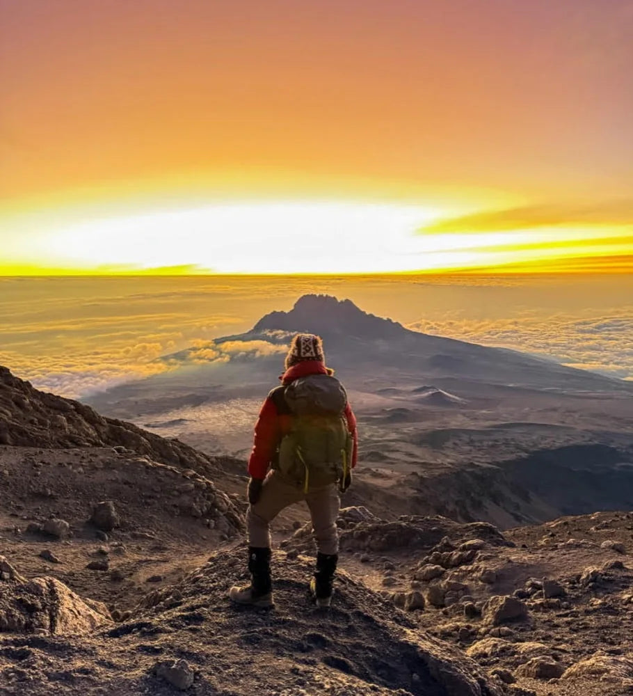 Stu, Natru founder, on a mountain summit at sunrise