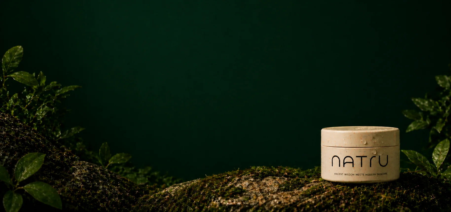 A jar of Natru Whipped Tallow resting on moss against a dark forest-green backdrop